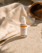 Skinmoods Sunscreen Tinted SPF30 with skinmoods towel on a rock on the beach